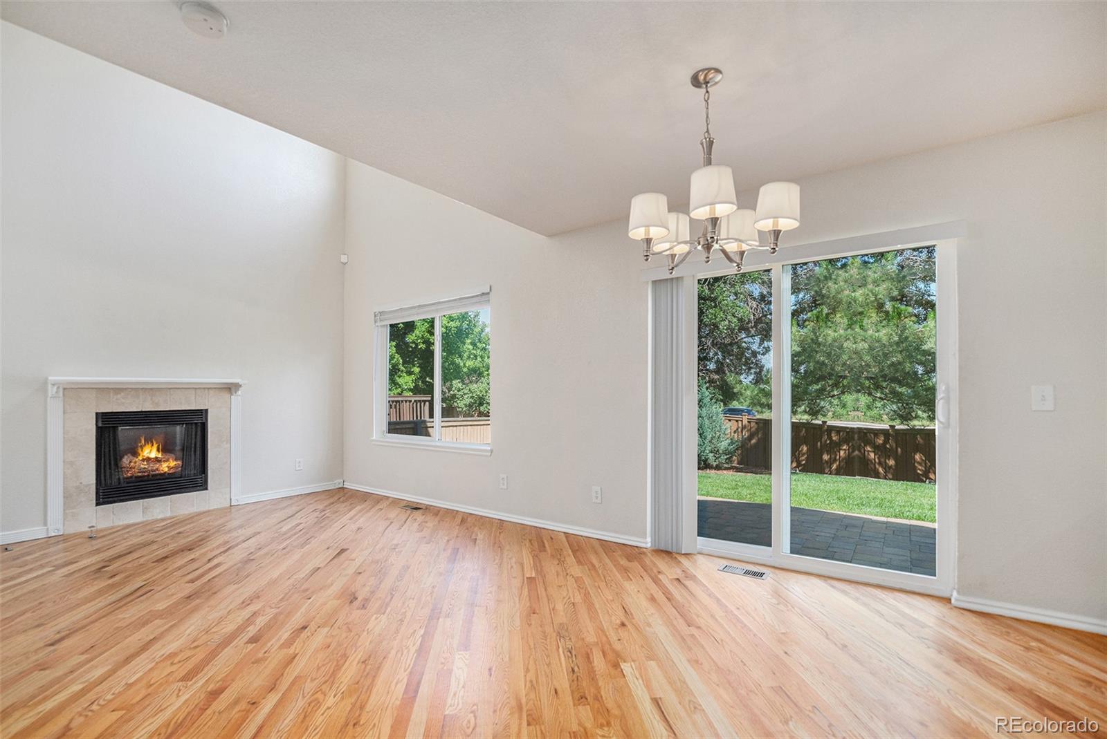 5253 Wangaratta Way Highlands Ranch, CO 80130 - Photo 5 of 43 a view of an empty room with wooden floor fireplace and a window