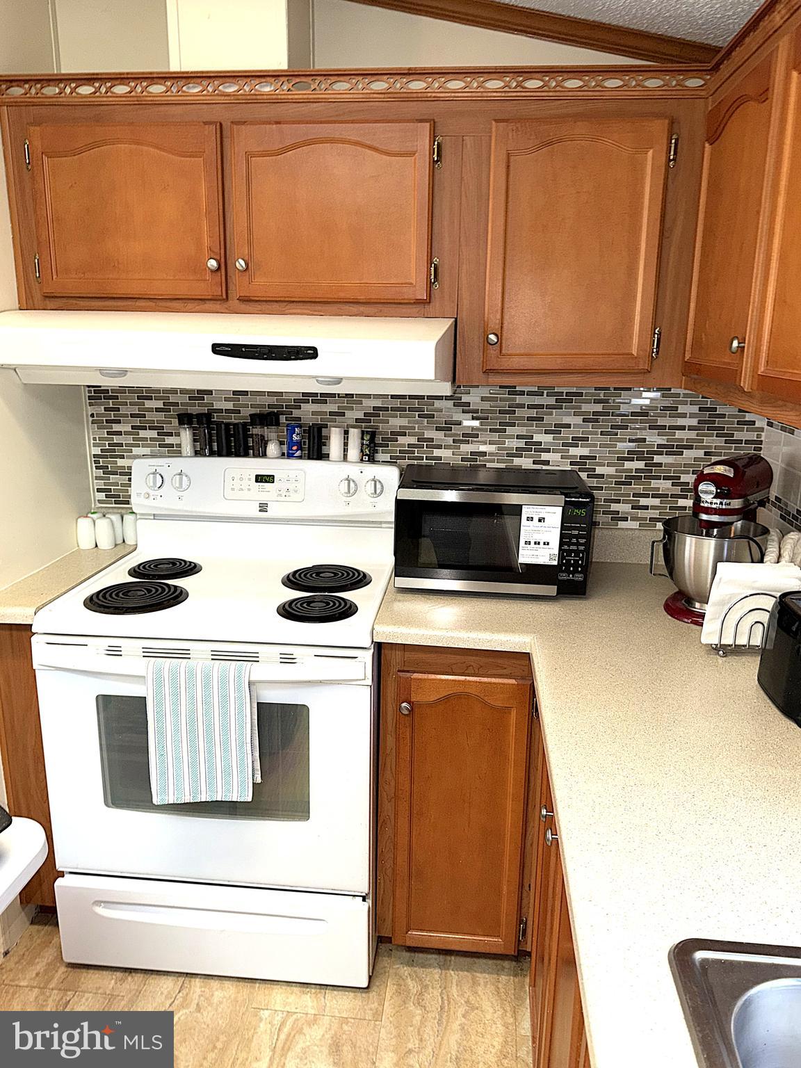 7959 Telegraph Road, Unit 15 Severn, MD 21144 - Photo 5 of 26 a kitchen with a stove and a microwave