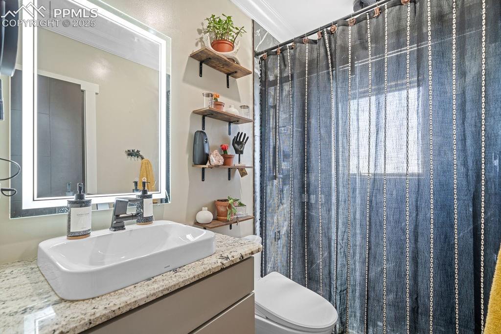 8450 Edison Road Yoder, CO 80864 - Photo 35 of 50 a bathroom with a granite countertop sink toilet and shower