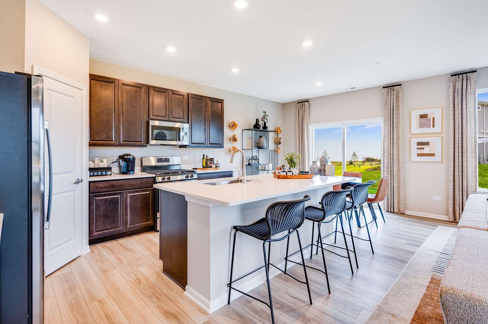 4220 Meadowridge Road Woodstock, IL 60098 - Photo 6 of 20 a kitchen with stainless steel appliances kitchen island granite countertop a table chairs and a refrigerator