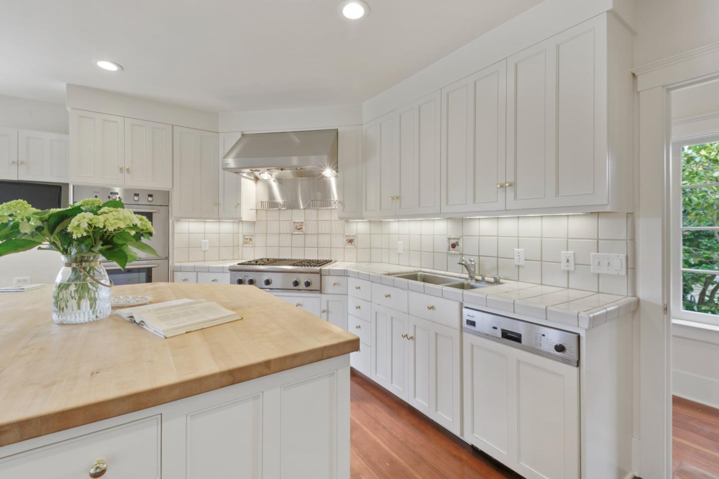 3929 Ronda Road Pebble Beach, CA 93953 - Photo 21 of 88 a kitchen with a sink a stove cabinets and wooden floor