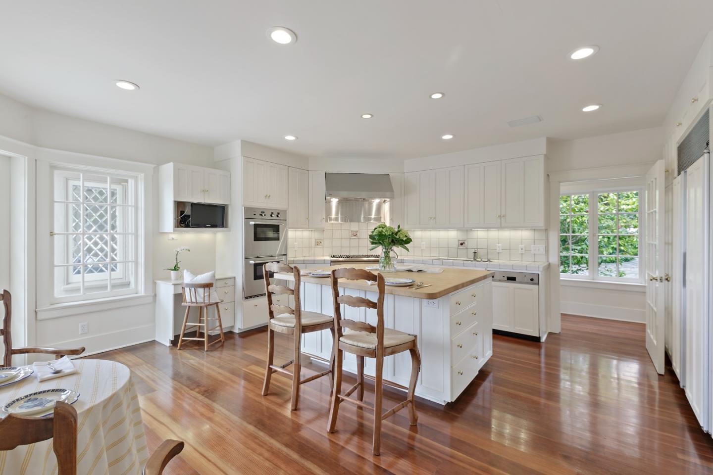 3929 Ronda Road Pebble Beach, CA 93953 - Photo 23 of 88 a kitchen with stainless steel appliances kitchen island granite countertop a stove a refrigerator a kitchen island with a dining table and chairs