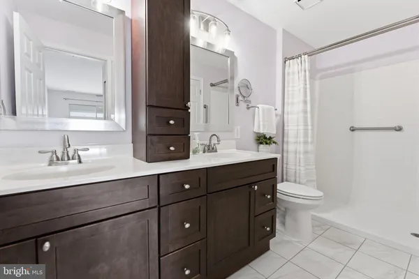 a bathroom with a double vanity sink toilet and a mirror