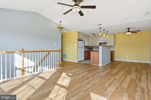 a view of a kitchen with a sink cabinet a ceiling fan and wooden floor
