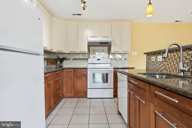 a kitchen with kitchen island granite countertop a sink stove and cabinets