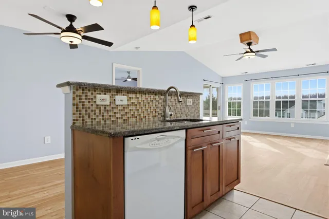a kitchen with stainless steel appliances granite countertop a sink and a refrigerator