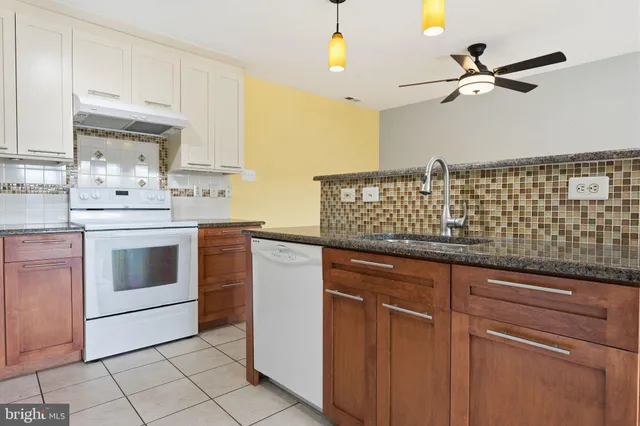 a kitchen with stainless steel appliances granite countertop a sink a stove and cabinets