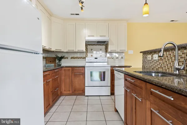 a kitchen with kitchen island granite countertop a sink stove and cabinets