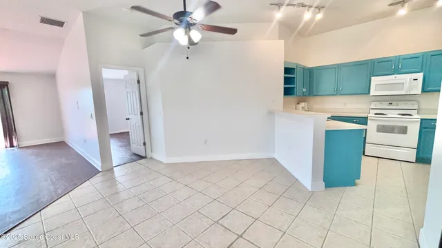 a view of a room with a large window a ceiling fan and wooden floor