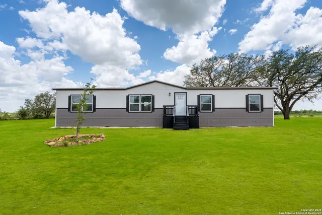 a backyard of a house with table and chairs
