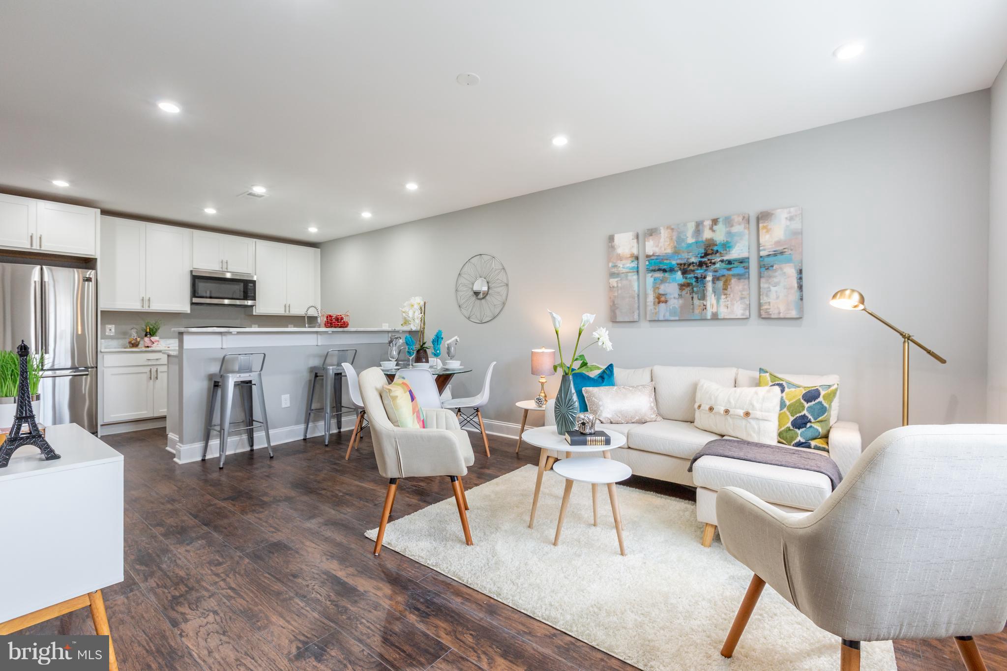 718 Jackson Street Northeast, Unit 1 Washington, DC 20017 - Photo 1 of 26 a living room with lots of furniture and kitchen view