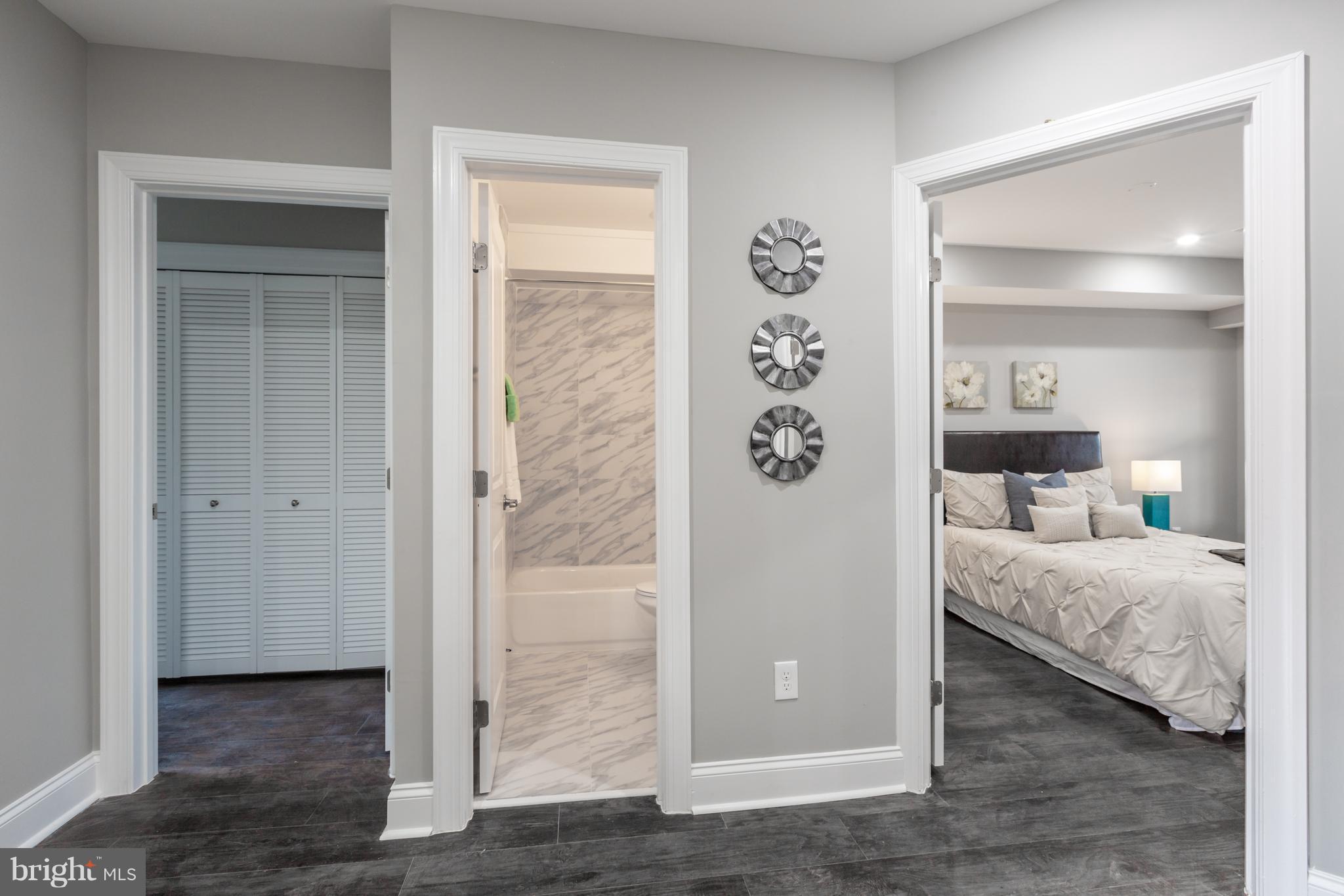 718 Jackson Street Northeast, Unit 1 Washington, DC 20017 - Photo 13 of 26 a bedroom with a bed and a mirror