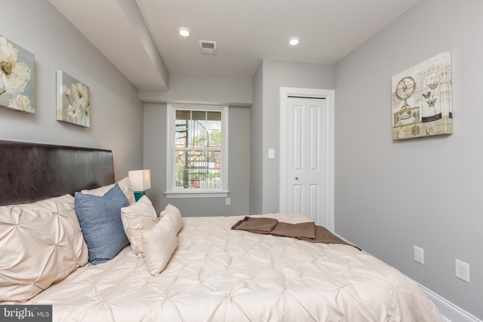 718 Jackson Street Northeast, Unit 1 Washington, DC 20017 - Photo 15 of 26 a bedroom with a large bed and a window