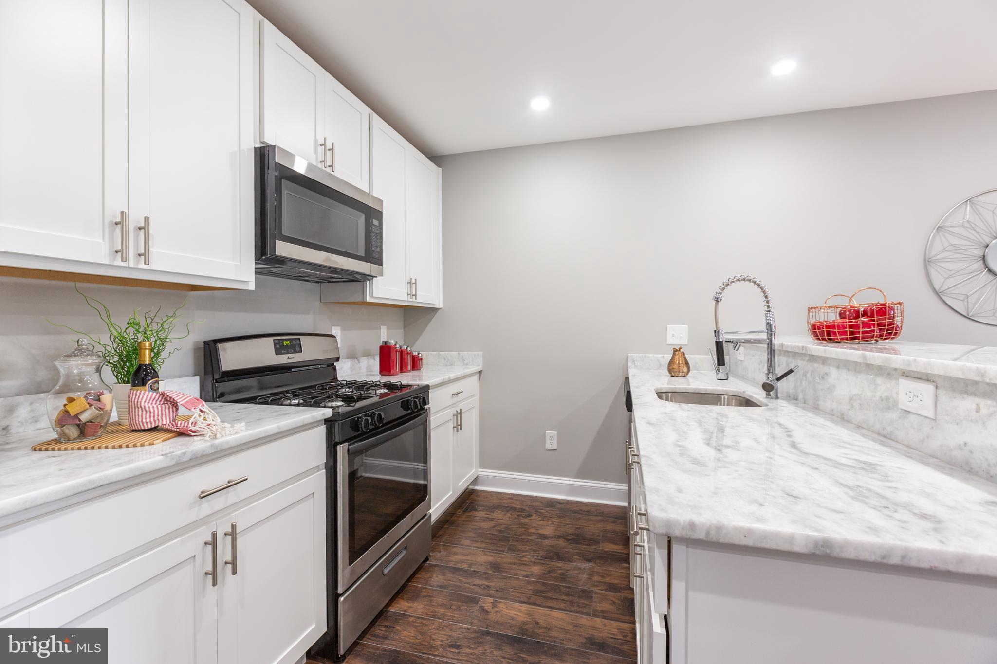 718 Jackson Street Northeast, Unit 1 Washington, DC 20017 - Photo 6 of 26 a kitchen with stainless steel appliances granite countertop a sink a stove and a microwave