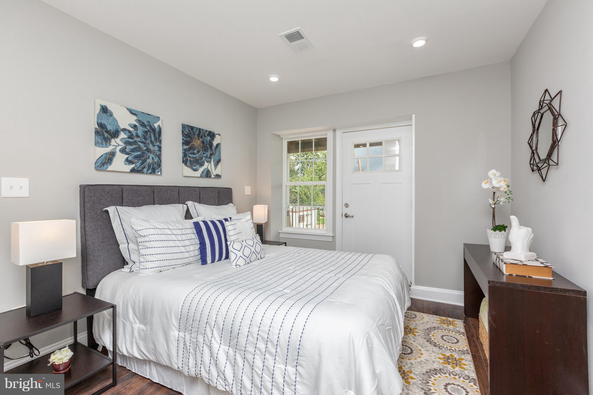 718 Jackson Street Northeast, Unit 1 Washington, DC 20017 - Photo 9 of 26 a bedroom with a large bed and a couch