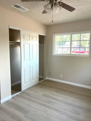an empty room with fan and windows