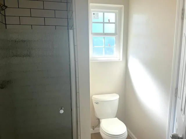 a white toilet sitting next to a window