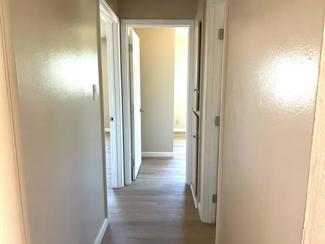a view of a hallway with wooden floor