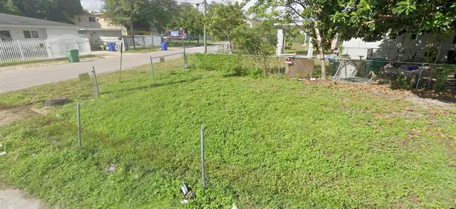 a view of a yard with plants and trees