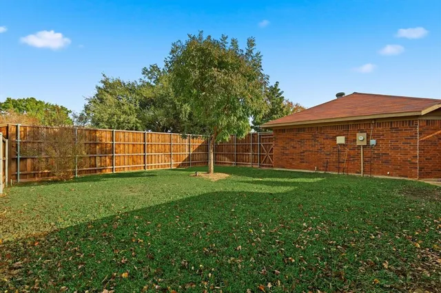 a view of a backyard with a garden and entertaining space