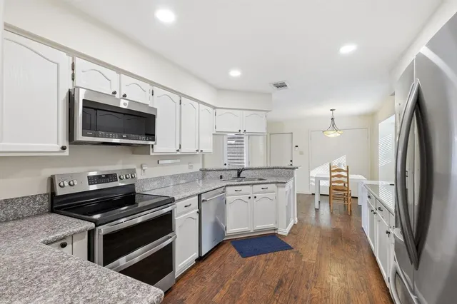a kitchen with stainless steel appliances a stove sink microwave and cabinets