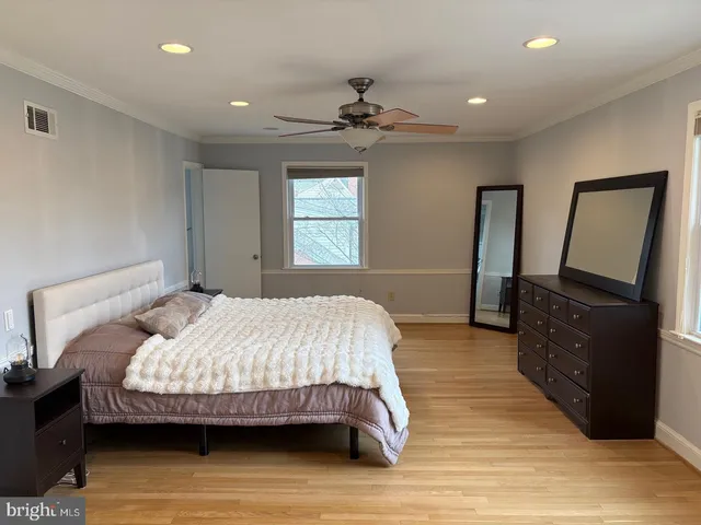 a bedroom with a bed wooden floor and window