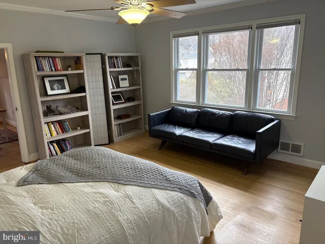 a bedroom with a bed a book shelf and a window