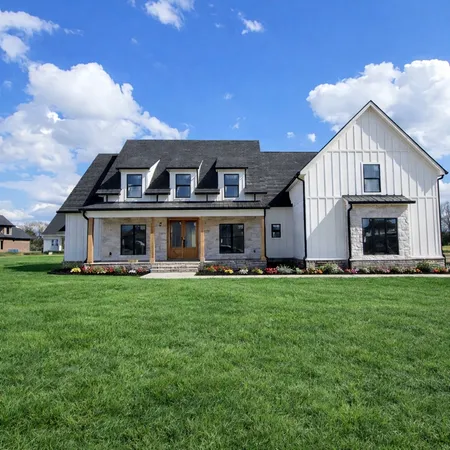 a front view of house with yard barbeque and outdoor seating