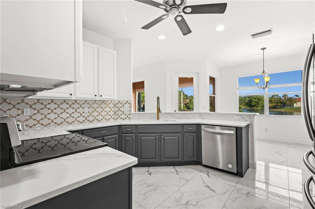 3972 Ruxton Road Naples, FL 34116 - Photo 5 of 41 a kitchen with stainless steel appliances a sink stove and cabinets