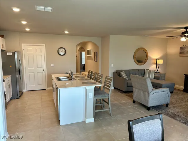 a living room with furniture a mirror and a large window