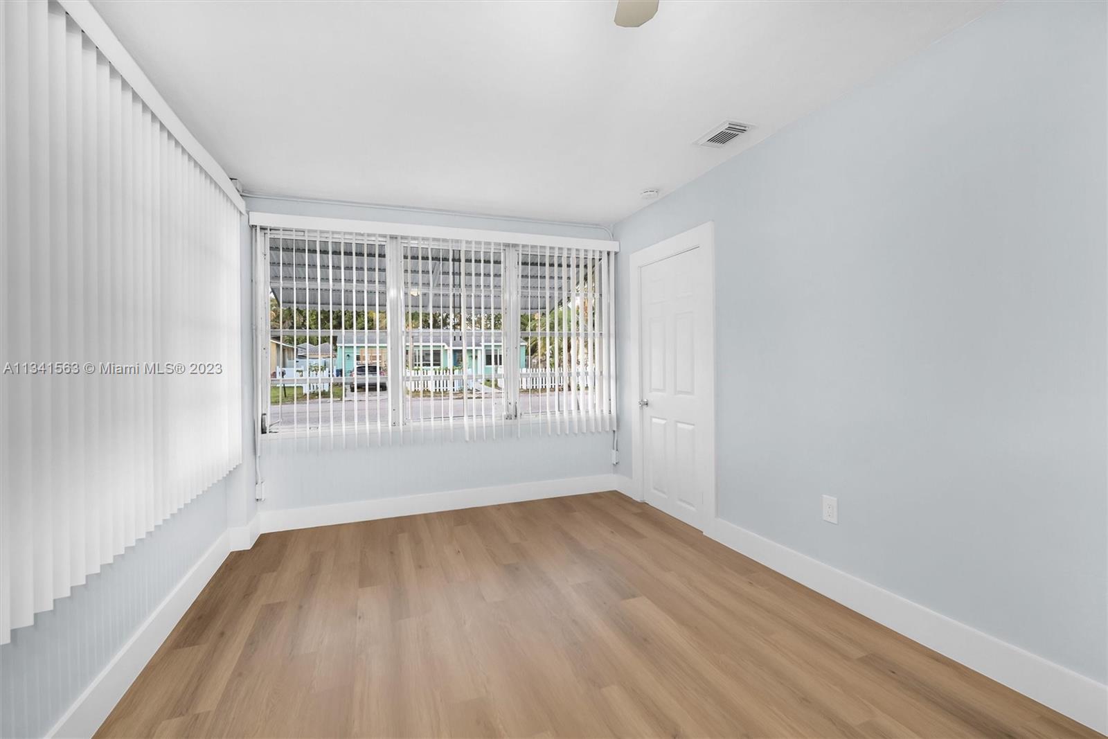 217 East 24th Street Riviera Beach, FL 33404 - Photo 12 of 27 wooden floor in an empty room with a window