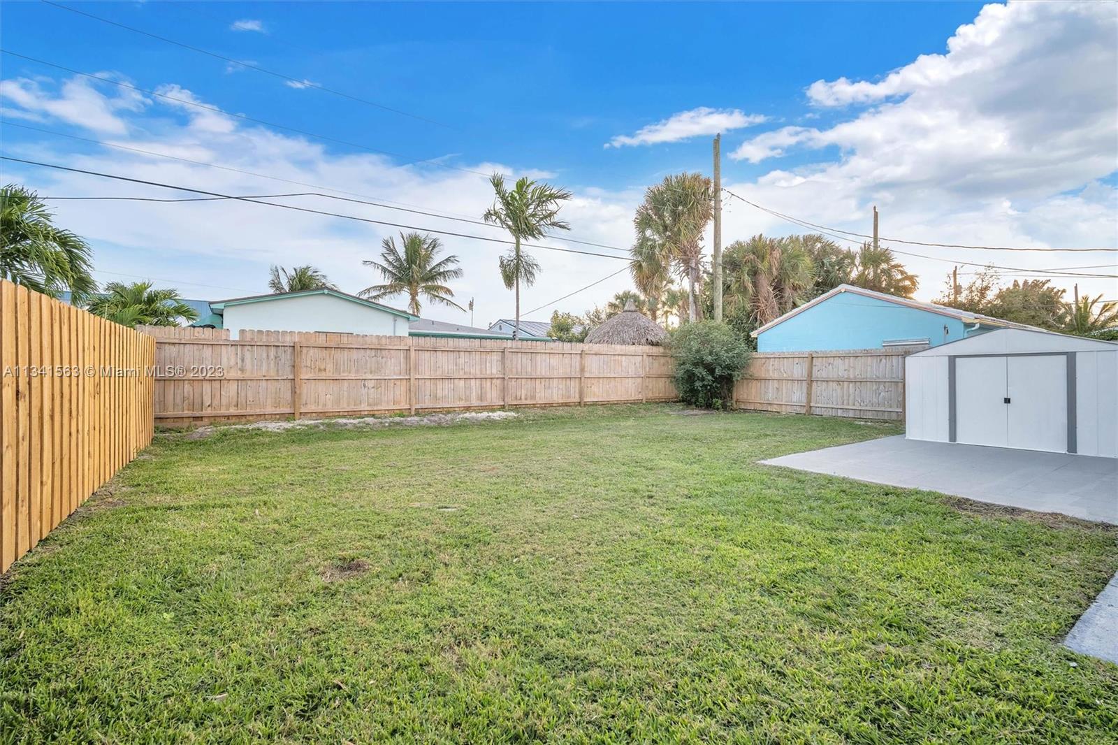 217 East 24th Street Riviera Beach, FL 33404 - Photo 17 of 27 a view of backyard with barn and large trees