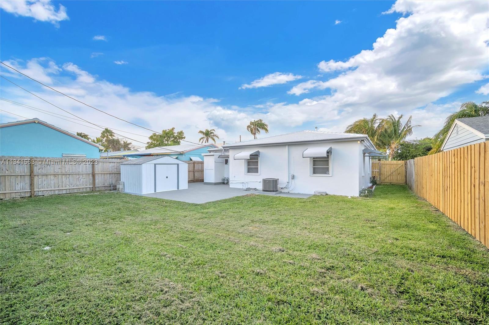 217 East 24th Street Riviera Beach, FL 33404 - Photo 18 of 27 a view of a yard in front of a house with a large tree
