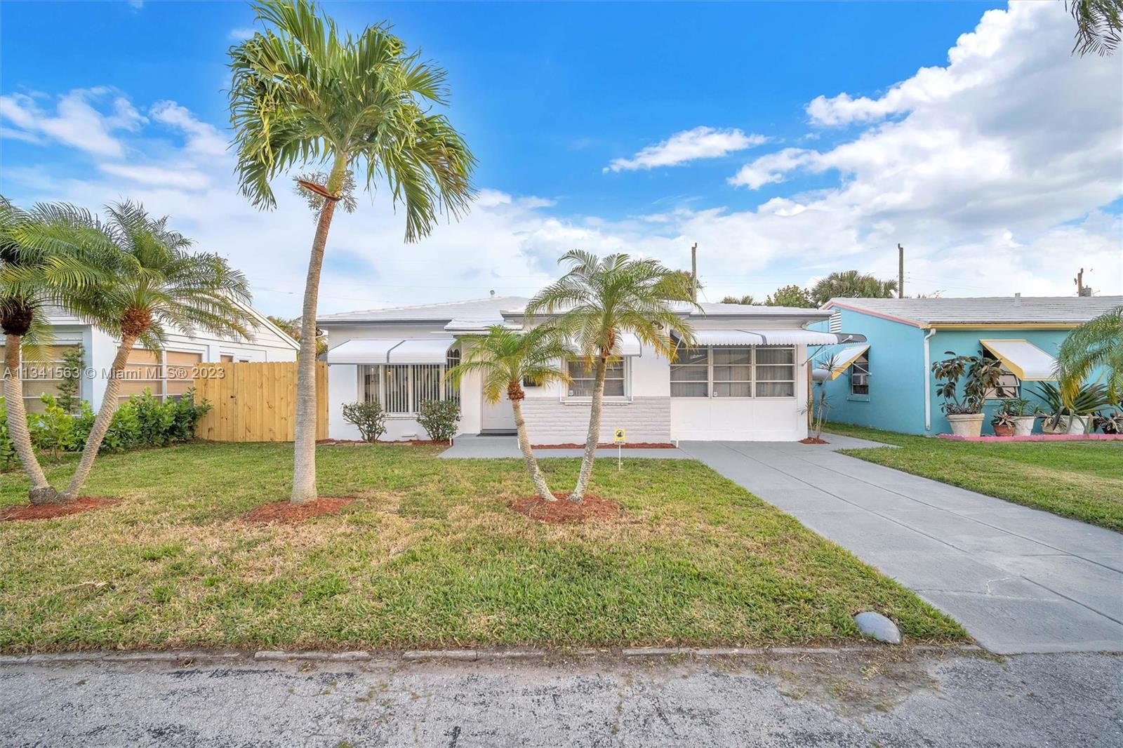 217 East 24th Street Riviera Beach, FL 33404 - Photo 2 of 27 a house with palm tree in front of it