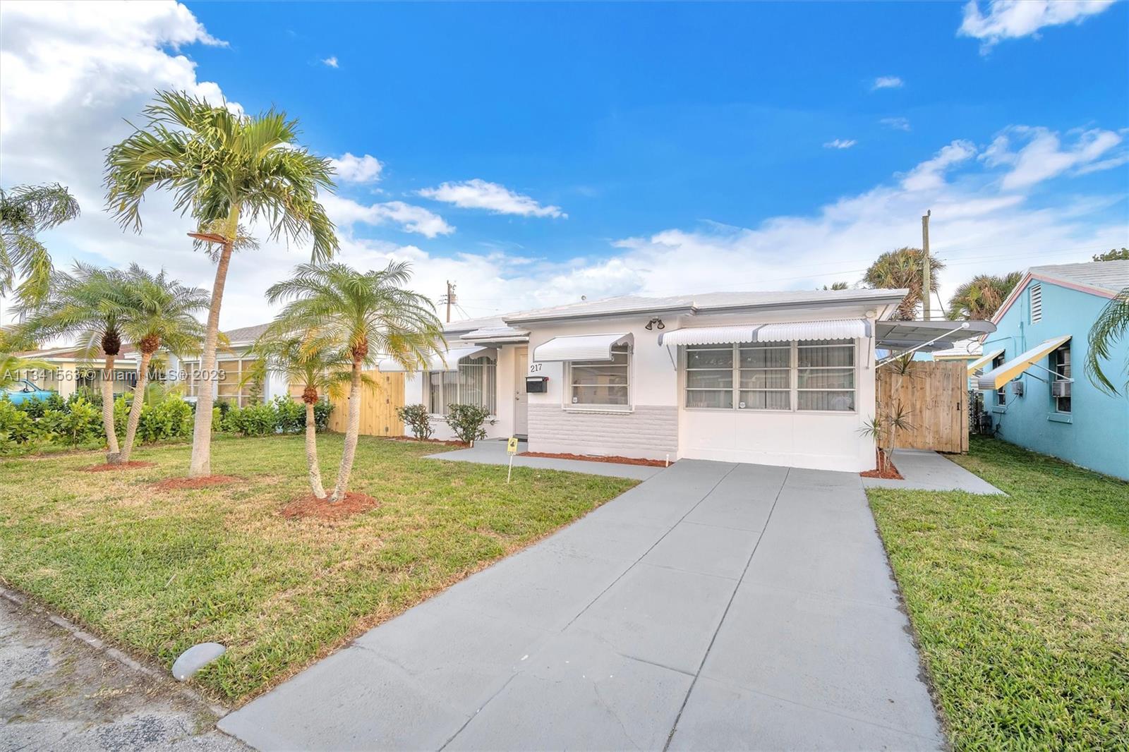 217 East 24th Street Riviera Beach, FL 33404 - Photo 26 of 27 a front view of a house with a yard