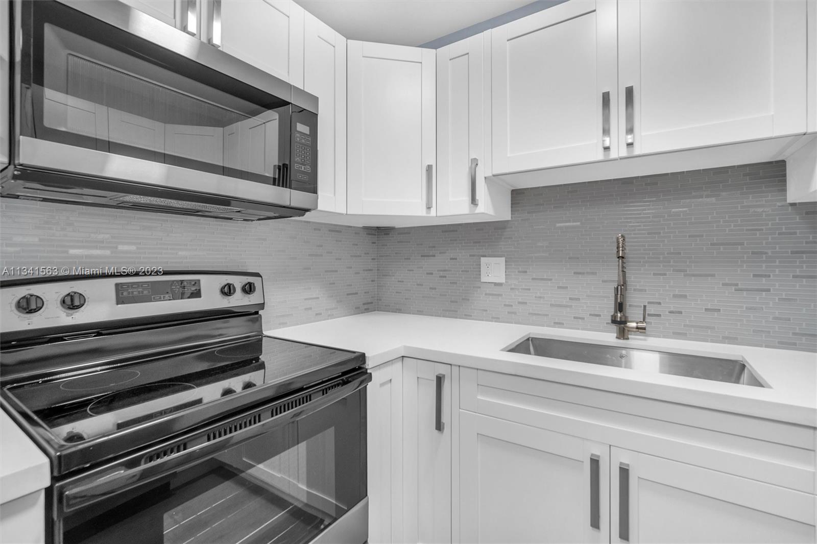 217 East 24th Street Riviera Beach, FL 33404 - Photo 4 of 27 a kitchen with a stove microwave and sink