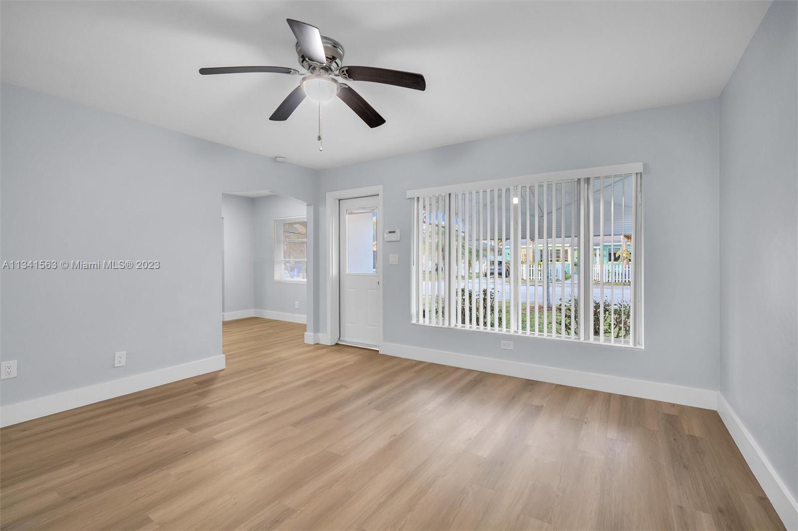 217 East 24th Street Riviera Beach, FL 33404 - Photo 8 of 27 a view of an empty room with a window and wooden floor