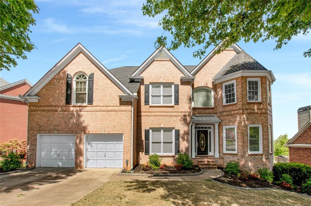a view of a house with a yard and large tree