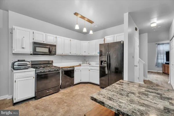 a kitchen with refrigerator a microwave a stove and cabinets