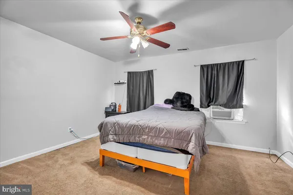 a bedroom with a bed and a ceiling fan