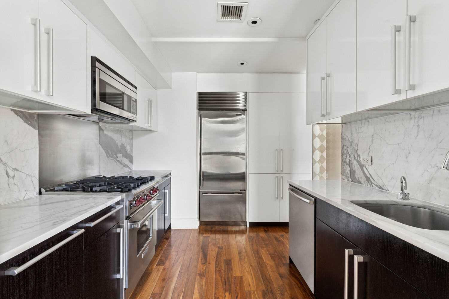 300 East 79th Street, Unit 10C Manhattan, NY 10075 - Photo 4 of 9 a kitchen with stainless steel appliances a sink stove and cabinets