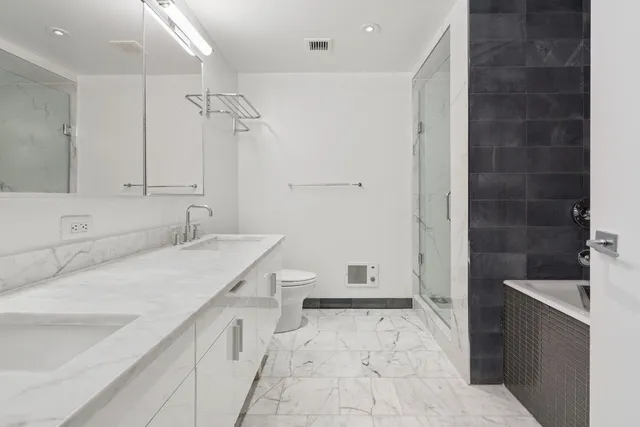 a bathroom with a sink a toilet and shower