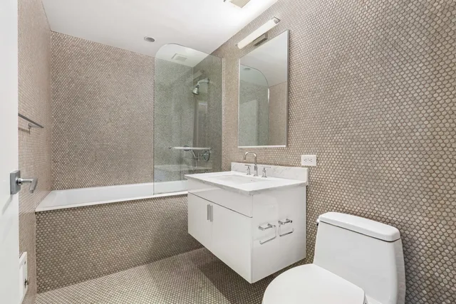 a bathroom with a toilet sink and mirror