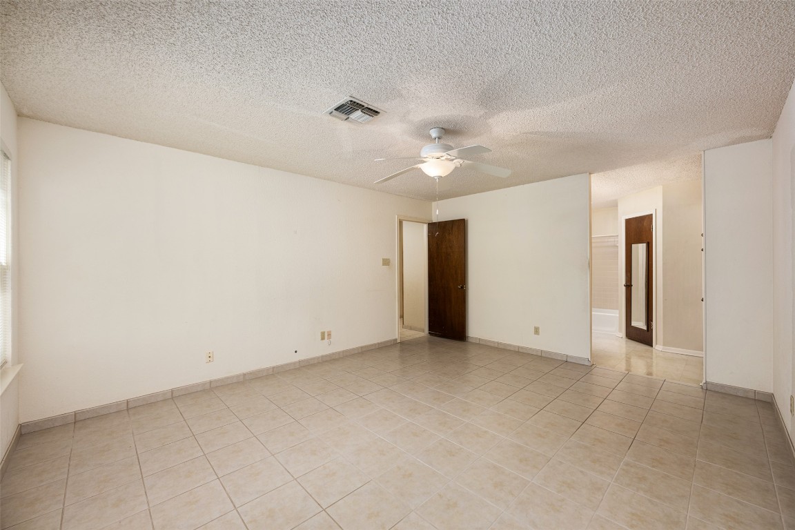 9424 El Rey Boulevard Austin, TX 78737 - Photo 14 of 35 an empty room with a ceiling fan and a window