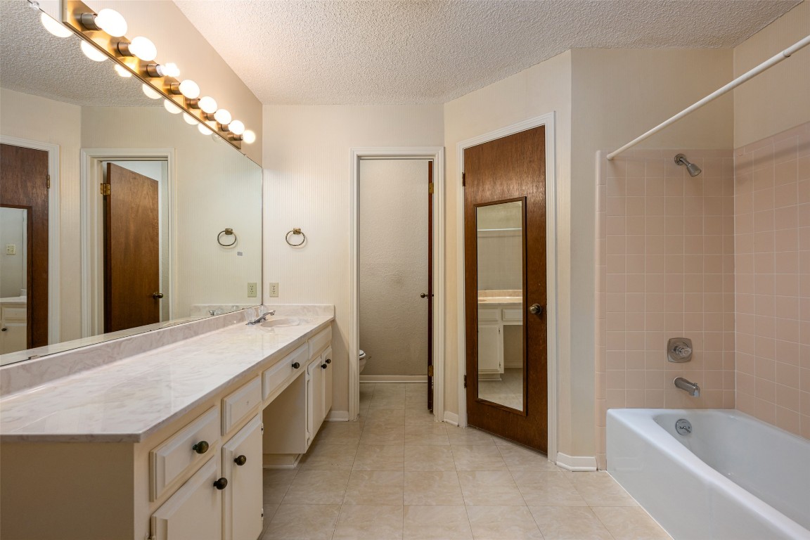 9424 El Rey Boulevard Austin, TX 78737 - Photo 15 of 35 a bathroom with a granite countertop sink a large mirror and a bathtub