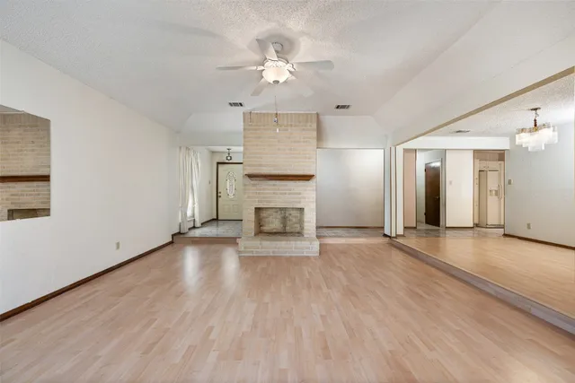 a view of a hallway with wooden floor and a bathroom