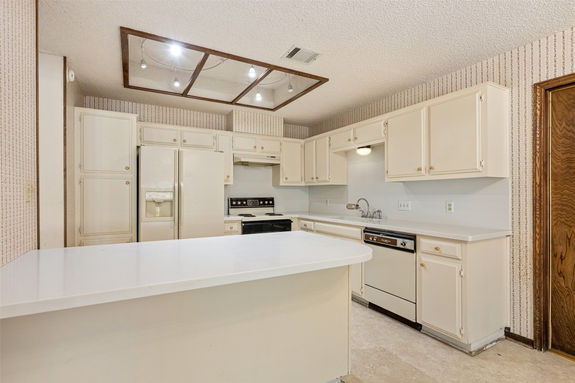 9424 El Rey Boulevard Austin, TX 78737 - Photo 10 of 35 a kitchen with stainless steel appliances and white cabinets