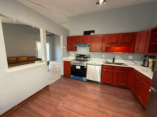 a kitchen with stainless steel appliances wooden cabinets a stove and a refrigerator