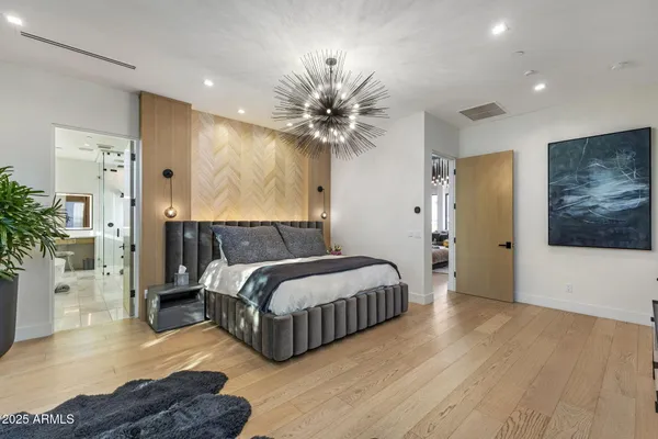 a bedroom with bed and a chandelier