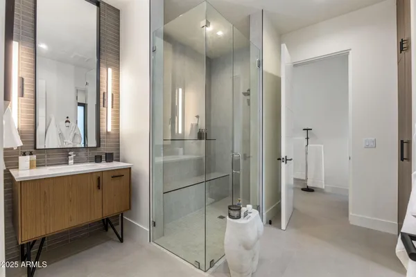 a bathroom with a double vanity sink a toilet and shower